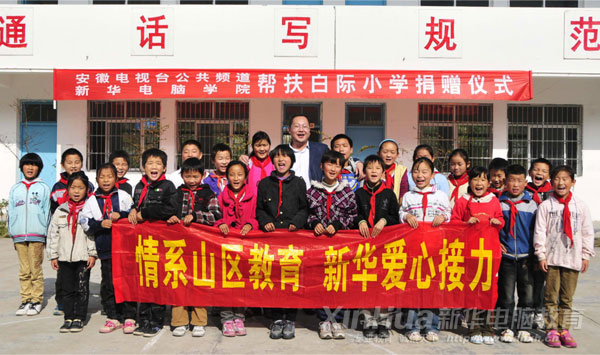 安徽新華電腦專修學院何貴金院長與白際小學的全體學生合影