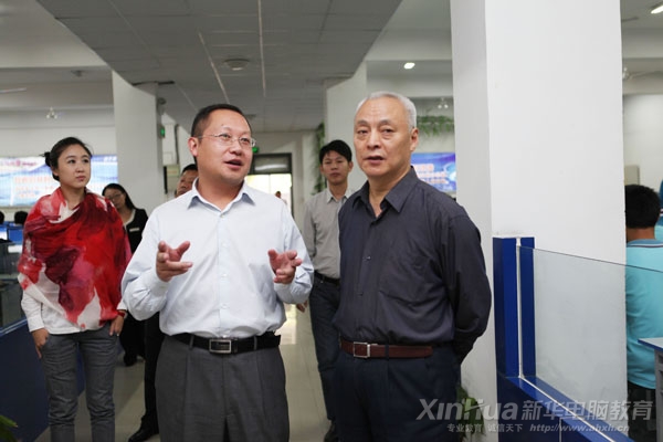 安徽新華電腦專修學院院長何貴金（左1）向畢主任（左2）介紹新華大型實訓機房